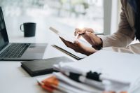 Foto: Frau mit Laptop und Taschenrechner